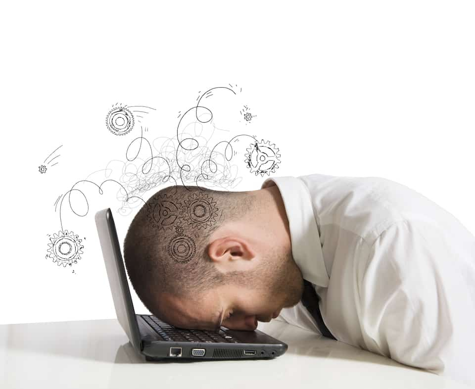 man with his head on the keyboard of his laptop with doodles around his head showing he is frustrated. 