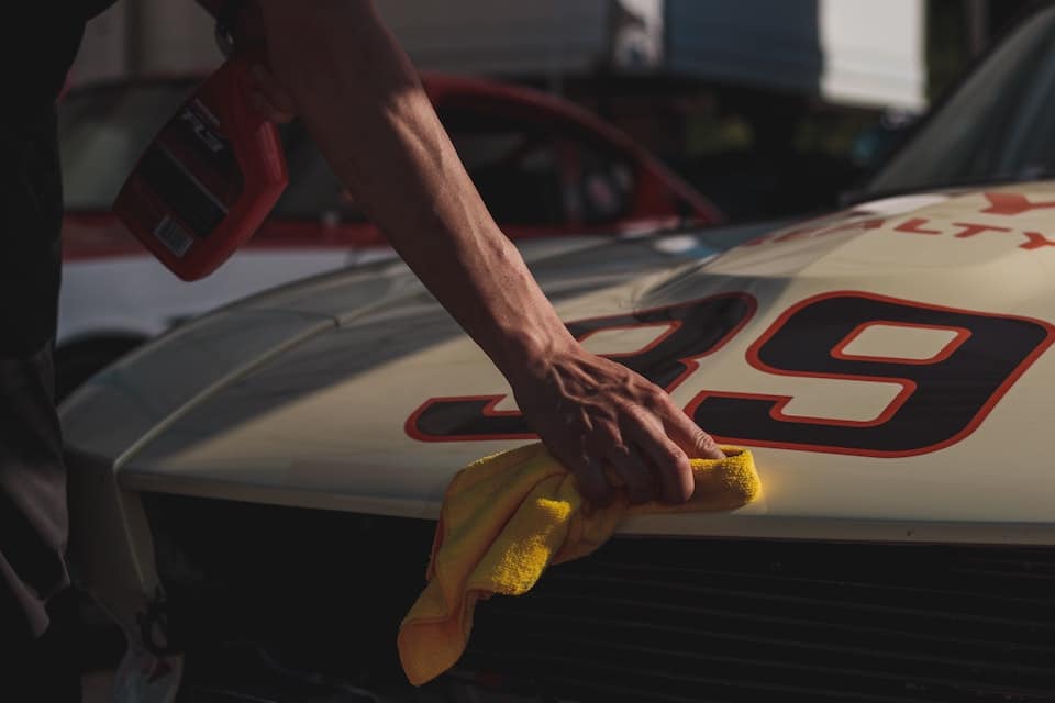 a hand polishing a race car